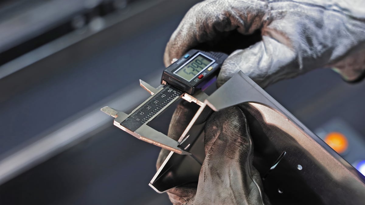 Trabajador midiendo pieza con vernier digital