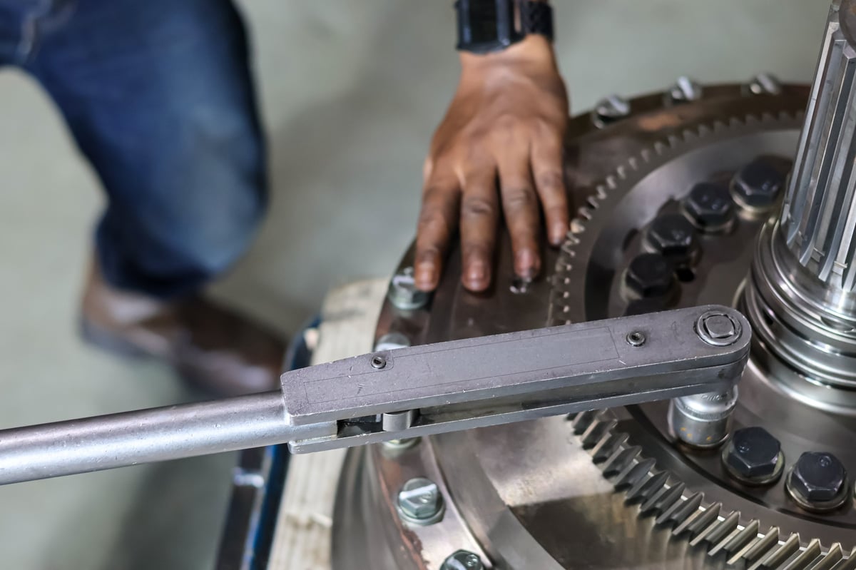 Técnico apretando pernos de maquinaria industrial